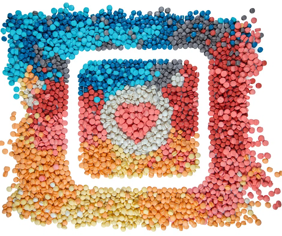 Buntes Kunstwerk aus kleinen, farbigen Objekten, die das Instagram-Logo mit Herzsymbol in der Mitte nachbilden.