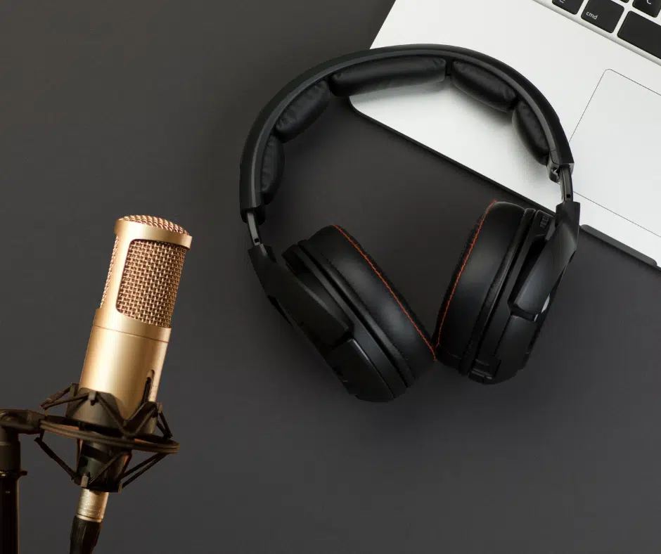 Podcast-Setup mit goldfarbenem Mikrofon, schwarzen Over-Ear-Kopfhörern und einem aufgeklappten Laptop.