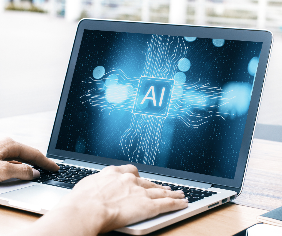 Das Bild zeigt einen Laptop mit einer grafischen Darstellung auf dem Bildschirm, die einen leuchtenden Schriftzug "AI" (für künstliche Intelligenz) in der Mitte zeigt, umgeben von digitalen Schaltkreismustern und blauen Lichtpunkten.