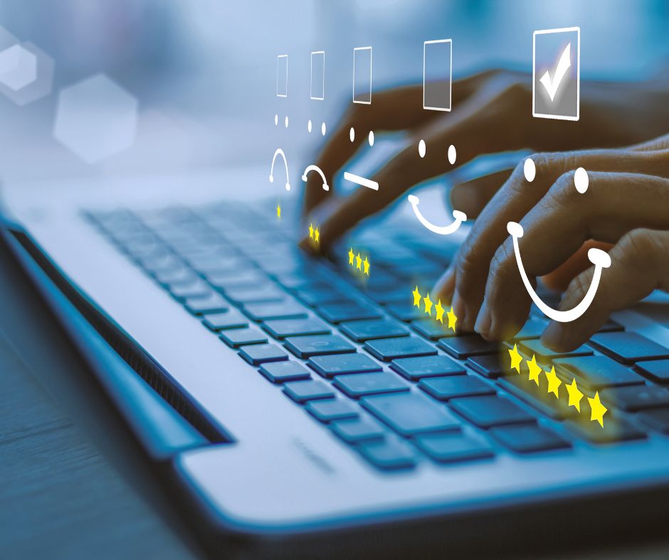 Symbolische Darstellung von Online-Bewertungen: Hände auf Laptop-Tastatur, darüber eingeblendete Sterne und Smileys zur Bewertung der Nutzerzufriedenheit.